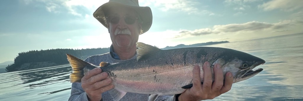 Ben Clarke holding a large salmon on a boat